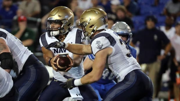 Oct 14, 2021; Memphis, Tennessee, USA; Navy Midshipmen quarterback Xavier Arline (7) hands the ball off to Navy Midshipmen running back Isaac Ruoss (32) at Liberty Bowl Memorial Stadium. Mandatory Credit: Petre Thomas-USA TODAY Sports